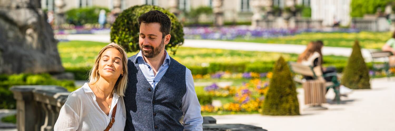 Couple enjoying the sun while walking in Mirabell Gardens | © TSG Tourismus Salzburg GmbH / M. Kohlmayr