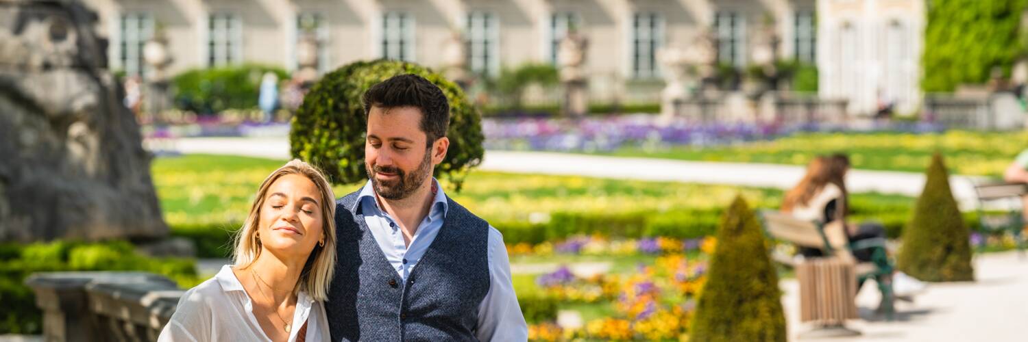 Paar genießt die Sonne beim Spazieren im Mirabellgarten | © Tourismus Salzburg GmbH / M. Kohlmayr