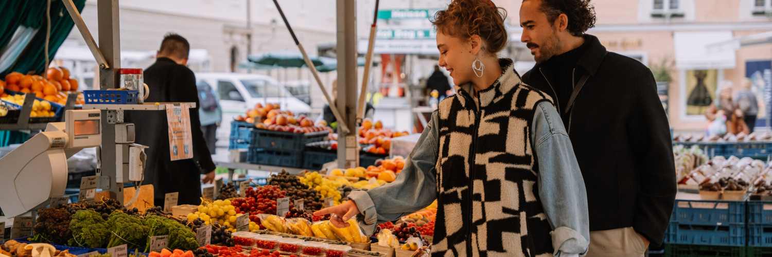 Zwei Menschen, die sich frische Ware am Grünmarkt in Salzburg ansehen | © TSG Tourismus Salzburg GmbH / M. Kohlmayr