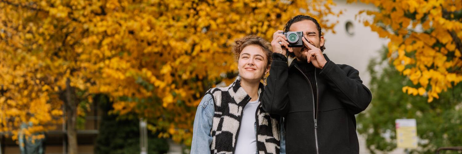 Zwei Menschen beim Sightseeing in Salzburg mit herbstlichen Bäumen im Hintergrund. | © TSG Tourismus Salzburg GmbH, Kohlmayr