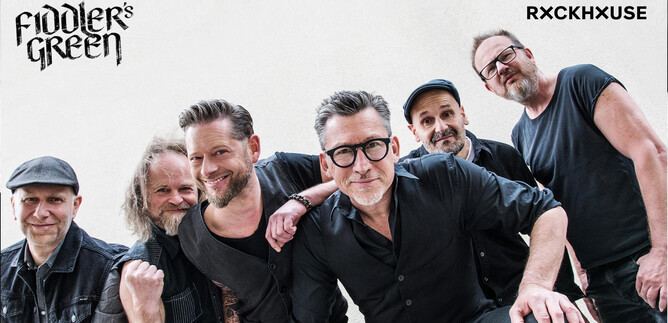 A band is happily posing for a photo. It consists of six members who are wearing casual clothing and are looking friendly at the camera. | © Franz Schepers