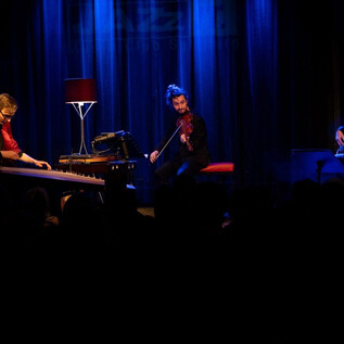 A lively stage with a band performing. The musicians are gathered together and presenting their show to an audience. | © Sven Wolf