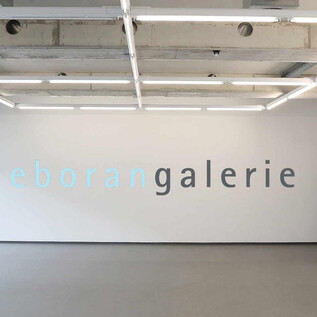 Une salle d'exposition moderne avec un design minimaliste. Au mur se trouve l'inscription "eboran galerie". | © Galerie Eboran
