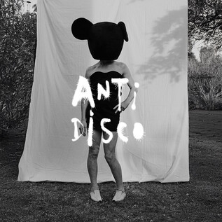 A person with a large, round head with ears stands in front of a white background. The inscription "ANTI DISCO" is prominently displayed in the center of the image. | © Roman Goebel