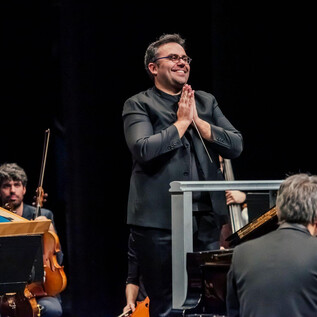 An orchestra is on stage in a magnificent hall. The audience is applauding enthusiastically. | © Atlántida Chamber Orchestra