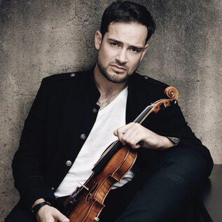 Ein Mann sitzt mit einer Geige in der Hand. Er trägt ein schwarzes Jackett und schaut ernst in die Kamera. | © recreation Event GmbH