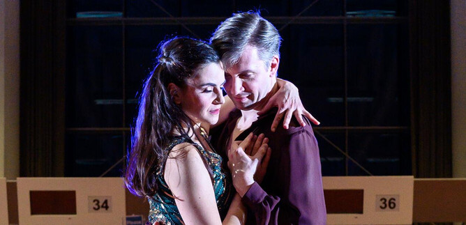 Ein Paar tanzt eng umschlungen auf einer Tanzfläche. Die Atmosphäre ist elegant und romantisch, mit sanfter Beleuchtung im Hintergrund. | © SLT / Tobias Witzgall