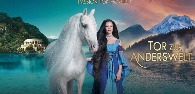 A beautiful image of a woman in a blue robe standing next to a white horse. In the background, mountains and a calm water surface can be seen. | © Cavalluna