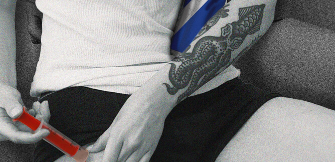 A person injects something into their thigh. The person's arm shows a detailed tattoo and the scene has a monochrome color palette with some colored accents. | © Calixto María Schmutter