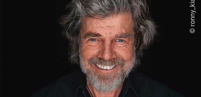 A smiling man with gray hair and a beard. He is wearing a black shirt and a necklace. | © ronny_kiaulehn