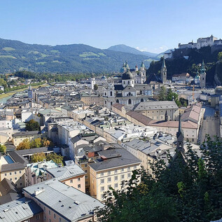 Pohled na město Salcburk s historickými budovami a pevností Hohensalzburg v pozadí. Hory a modré nebe dotvářejí krásný krajinný obraz. | © Wienerroither Sylvia