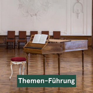 Ein historisches Klavier steht im Raum, daneben ein eleganter Stuhl. Die Umgebung strahlt eine klassische Atmosphäre aus. | © DomQuartier