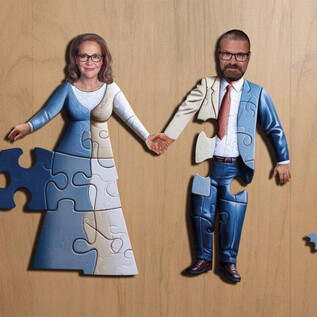 Ein Puzzlespiel zeigt zwei Figuren, eine Frau in einem Hochzeitskleid und einen Mann im Anzug, die Händchen halten. Einige Puzzlestücke sind noch fehlend, was eine unvollständige Verbindung darstellt. | © Manfred Baumann