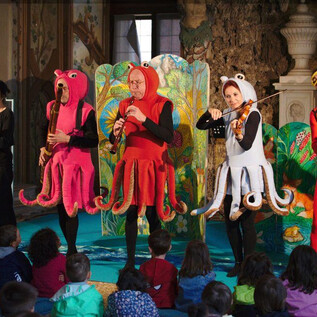 Představení s herci v barevných kostýmech jako chobotnice. Děti sedí v publiku a s napětím sledují. | © Jeunesse