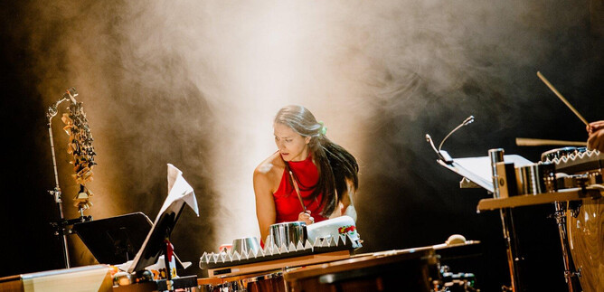 A musician is playing an instrument on stage. In the background, a fog-filled atmosphere can be seen. | © Salzburger Kulturvereinigung