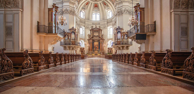 Una grande navata della chiesa con un altare sontuoso. Il soffitto è artisticamente decorato e la luce cade dolcemente sul pavimento. | © Eva trifft. FOTOGRAFIE