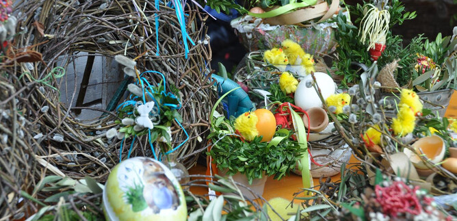 Barevné velikonocní dekorace s vejci, umělými kuřaty a čerstvými rostlinami. Stůl je slavnostně zdoben větvemi a květinami. | © Salzburger Freilichtmuseum