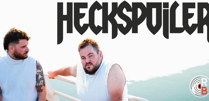 Two men are sitting on a boat, looking thoughtfully into the distance. In the background, the water and the sky can be seen. | © Heckspoiler