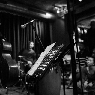 Una actuación de música en vivo en un pequeño y acogedor lugar. Los músicos tocan en el escenario, mientras el público observa atentamente. | © Jazzit