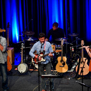 Un groupe se produit sur scène. Il y a plusieurs instruments et les musiciens jouent avec passion. | © Heinz Bayer