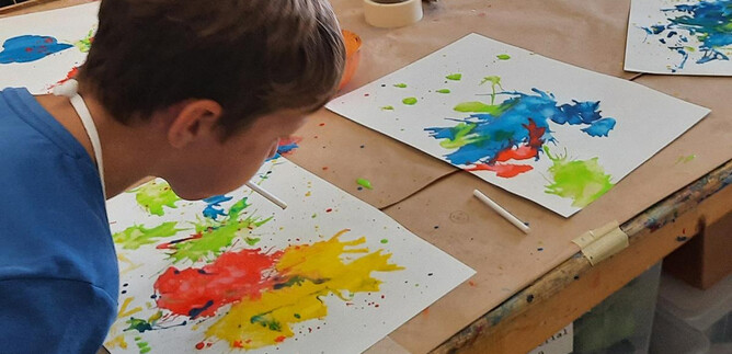 Une collection de crayons de couleur et de ciseaux dans des contenants en métal. Au premier plan, des bols orange sont visibles. | © DomQuartier