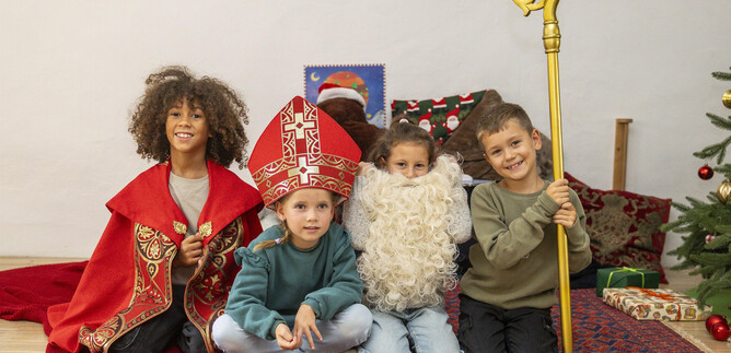 Két tök Halloween-motívumokkal áll egy asztalon. Az egyik tök világító és vidám arca van, míg a másik szerszámokkal van díszítve. | © Khan Eram/Spielzeug Museum