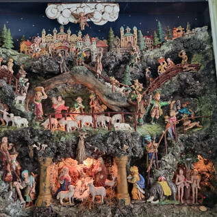 Una presepe ricca di dettagli con molte figure che rappresentano diverse scene. Sullo sfondo si possono vedere paesaggi e edifici stilizzati. | © Bibelwelt
