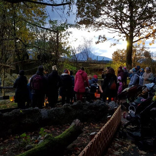 Un grupo de personas está en un parque y mira un hermoso paisaje. Es tarde y la atmósfera es tranquila y otoñal. | © Zoo Salzburg