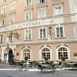 A charming hotel with the sign "Hotel Altstadt" and a café. Tables and chairs are set up in front of the facade in a picturesque street. | © Radisson Blu Hotel Altstadt