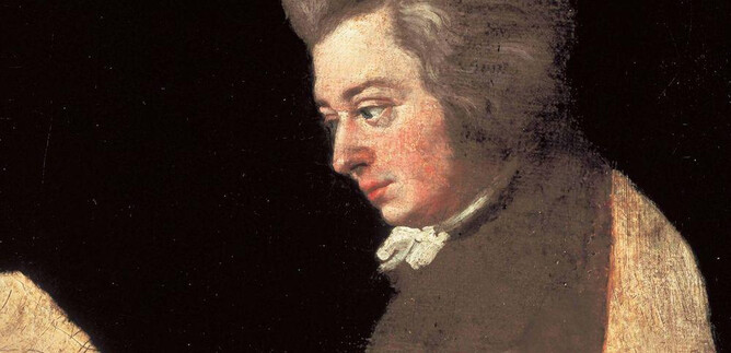 A portrait of a man with a styled haircut and a black garment. He is looking to the left and has a thoughtful expression. | © ISM