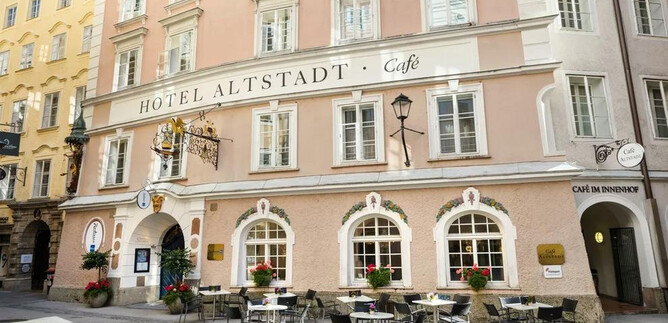 A charming hotel with a cozy café outdoor area. The facade in soft colors radiates an inviting atmosphere. | © Radisson Blu Hotel Altstadt