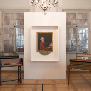 An exhibition room with two musical instruments, a pianoforte and a clavichord. In the middle, a portrait hangs, adorning the wall. | © Wolfgang Lienbacher
