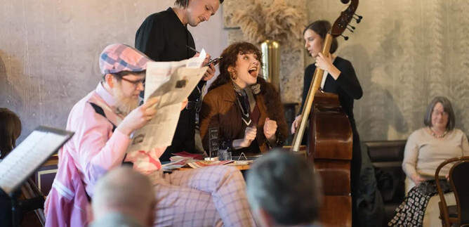A vibrant live performance in a cozy café. The singer entertains the audience while the musicians play in the background. | © Wolfgang Lienbacher