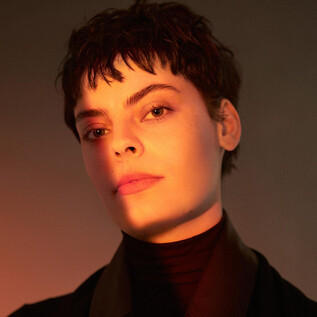 A portrait of a person with short, dark hair. The soft light creates a warm, dramatic effect. | © Mark Pillao