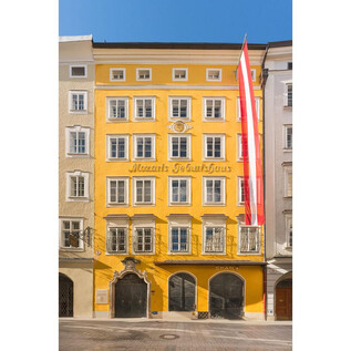 A yellow building with many windows and a striking facade. Two red flags are hanging on the side. | © ISM_Wolfgang Lienbacher