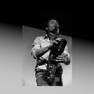 Un musicista suona il sassofono su un palco. Ha un aspetto concentrato ed è circondato da un'atmosfera emotiva. | © Isabel Cardeira