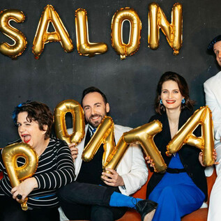 A group of four people is sitting on a couch and holding golden balloon letters. They form the word "SALON SPONTAN" in the background. | © Sarah Baum