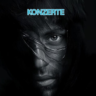 Dramatický portrét muže s pronikavým pohledem. Pozadí je tmavé a nápis "KONCERTY" se vyjíma v horní části. | © Mathias Vef