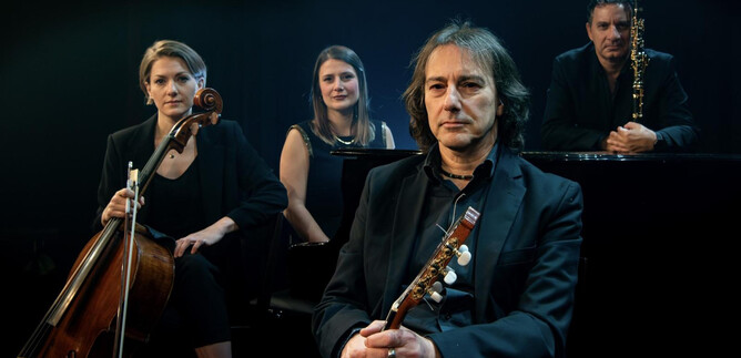 A group of four musicians poses on stage. They play different instruments and exude a creative atmosphere. | © Pippo Pollina | Konzertphotograph