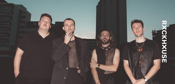A group of four men stands in front of an urban background. The scene conveys a modern and stylish ambiance. | © Arne Müseler