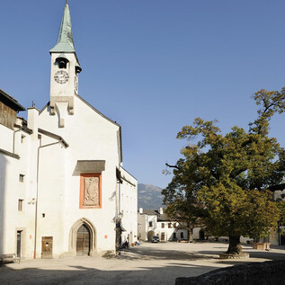 A quiet place with a white church and a large tree. The sky is clear and blue, creating a peaceful atmosphere. | © Salzburger Burgen und Schlösser