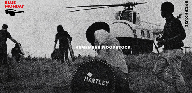 Eine Gruppe von Menschen bewegt sich in einem Feld, während ein Hubschrauber im Hintergrund schwebt. In der Mitte der Szene ist ein großer Koffer mit der Aufschrift "HARTLEY" zu sehen. | © Rockhouse Salzburg