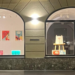 A modern display window with bright, colorful artworks. Inside, there is an easel that suggests a creative atmosphere. | © Galerie Haas & Gschwandnter