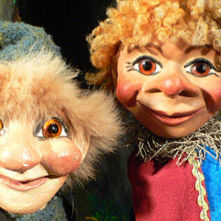 Zwei bunte Puppen mit freundlichen Gesichtern. Die eine hat lockige Haare und die andere eine spitze Mütze. | © Sindri Puppentheater