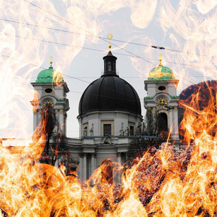 Historická budova s nádhernou kupolí a zelenými věžičkami. Obklopena plameny, které vytvářejí dramatickou atmosféru. | © Mag. Christoph Koca