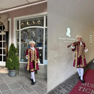 Historyczny budynek z tablicą "Furst" i dwoma roślinami doniczkowymi przed drzwiami. Po drugiej stronie stoi osoba w historycznym kostiumie z skrzypcami przed wejściem do "Mozart Geburtshaus". | © Sabine Rath