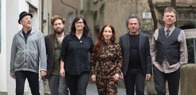 A group of six people strolls leisurely down a street. They are wearing various stylish outfits and seem to be having a great time. | © Wolfgang Lienbacher