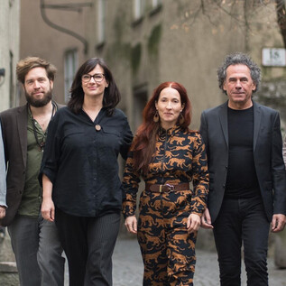 Eine Gruppe von sechs Personen geht entspannt eine Straße entlang. Sie tragen unterschiedliche, stilvolle Outfits und scheinen sich gut zu amüsieren. | © Wolfgang Lienbacher