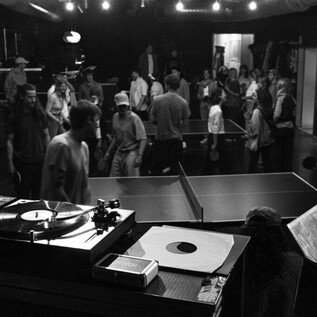 A lively event with several people playing table tennis. In the foreground is a DJ setup. | © Harald Gaukel