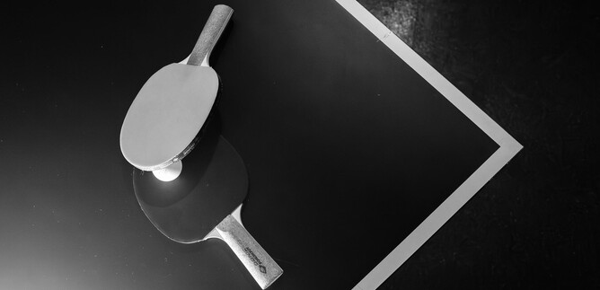 An elegant hand mirror lies on a dark surface. Its reflective design creates an interesting contrast. | © Stick Ford